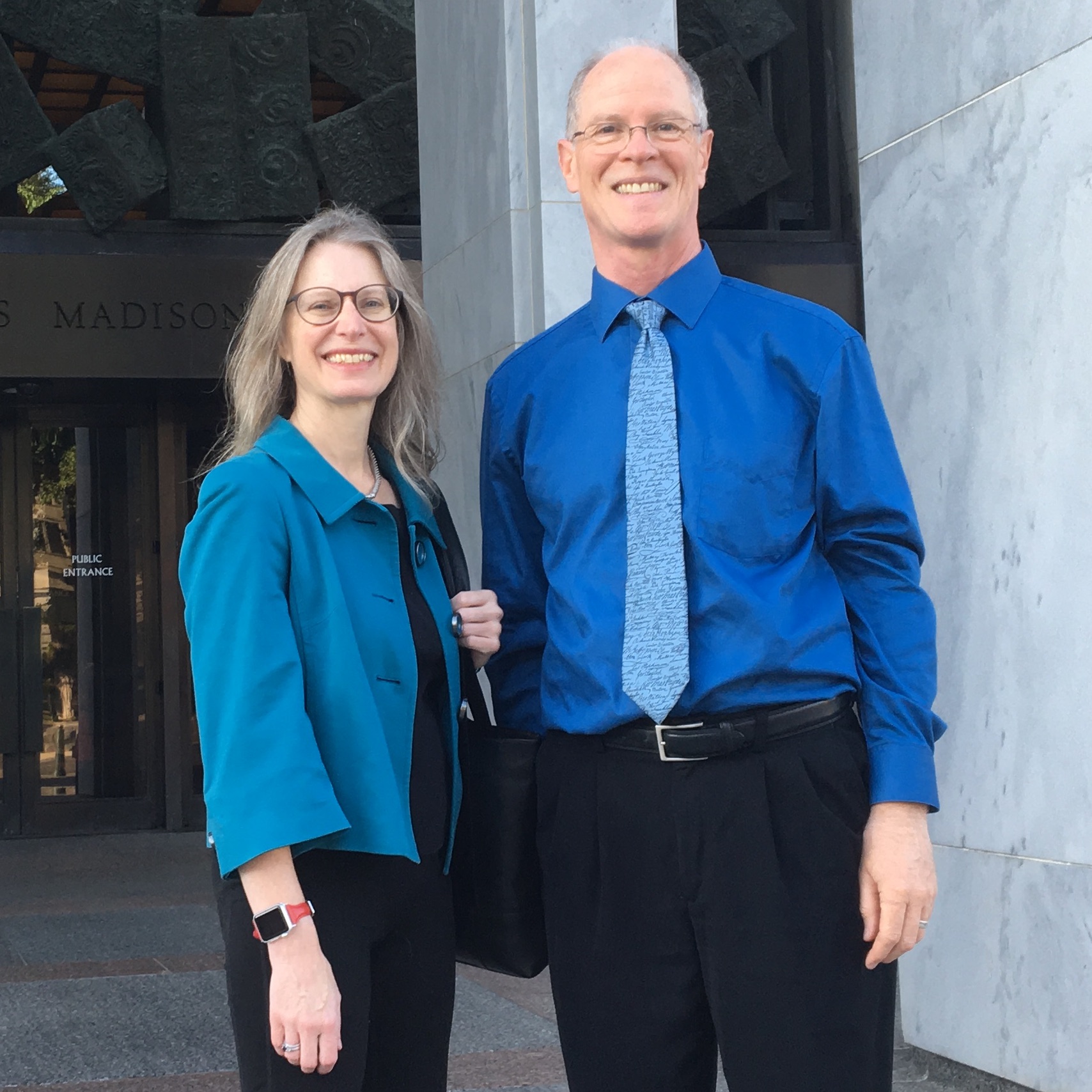 Alison Noyes and Rich Cairn smile as they stand in front of Madison Building of the Library of Congress.