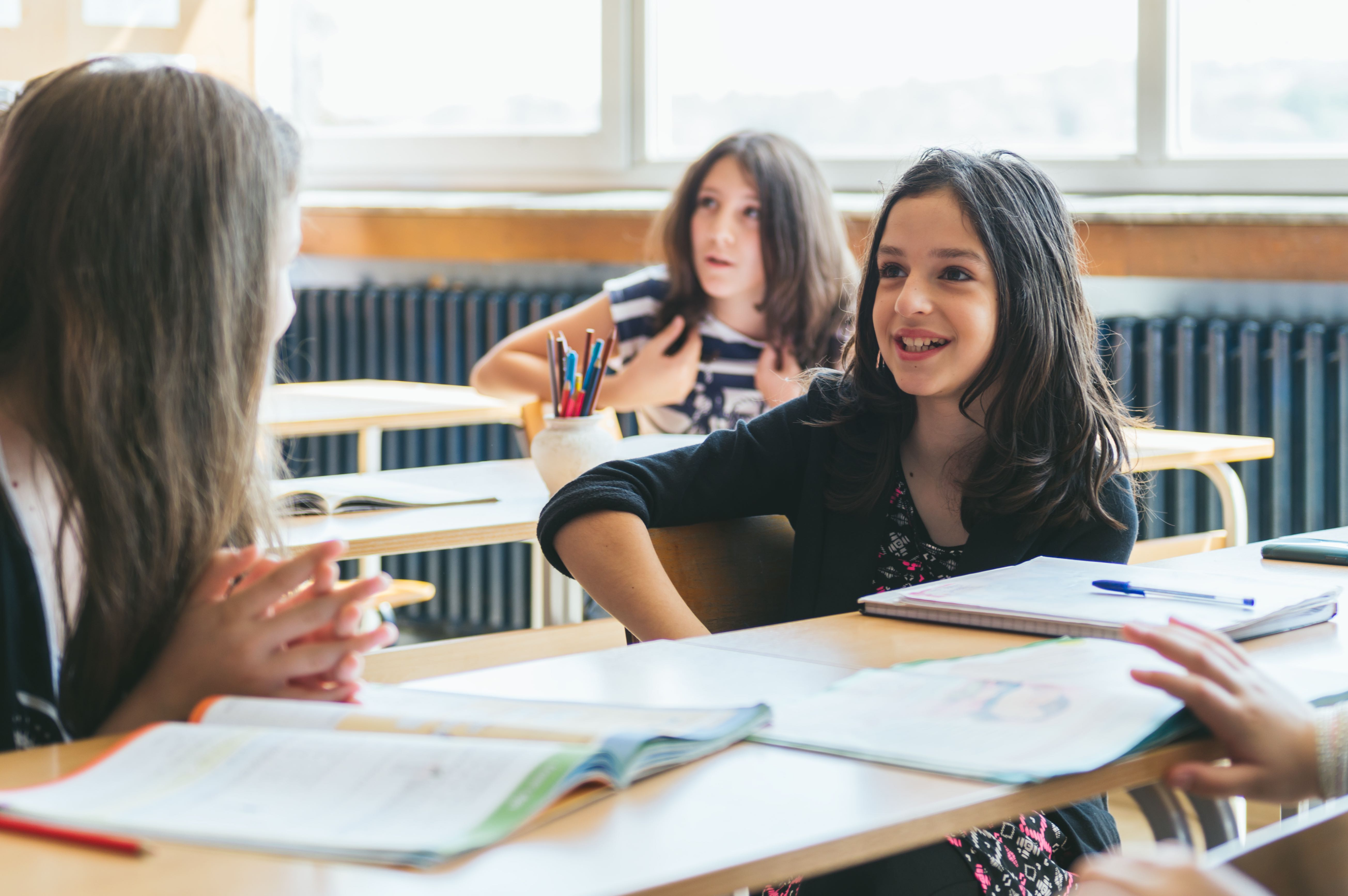 Elementary girls work on a project at their desks.