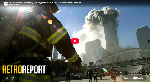 A firefighter wearing an oxygen tank is in the foreground. Dozens of other firefighters walk toward the Twin Towers which are on fire with clouds of smoke. Title reads: RetroReport. 9/11 Heroes: Surviving the Biggest Attack on U.S. Soil.