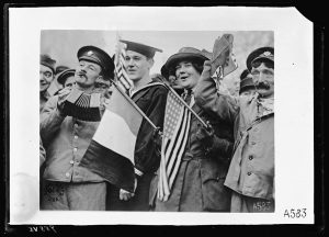 Picture of a group of people holding a mix of signs included French and American in Paris.