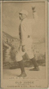 Gray scale picture of a baseball player throwing a ball.