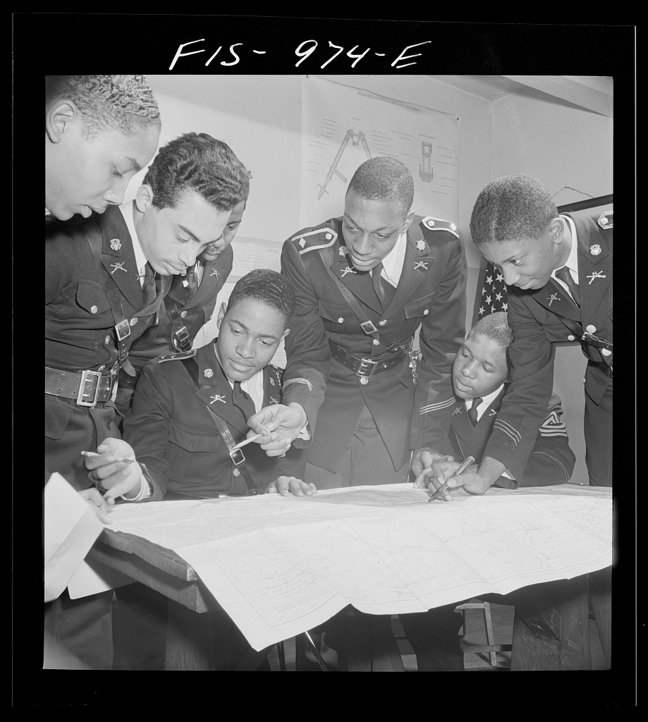 Students huddle over a map. 
