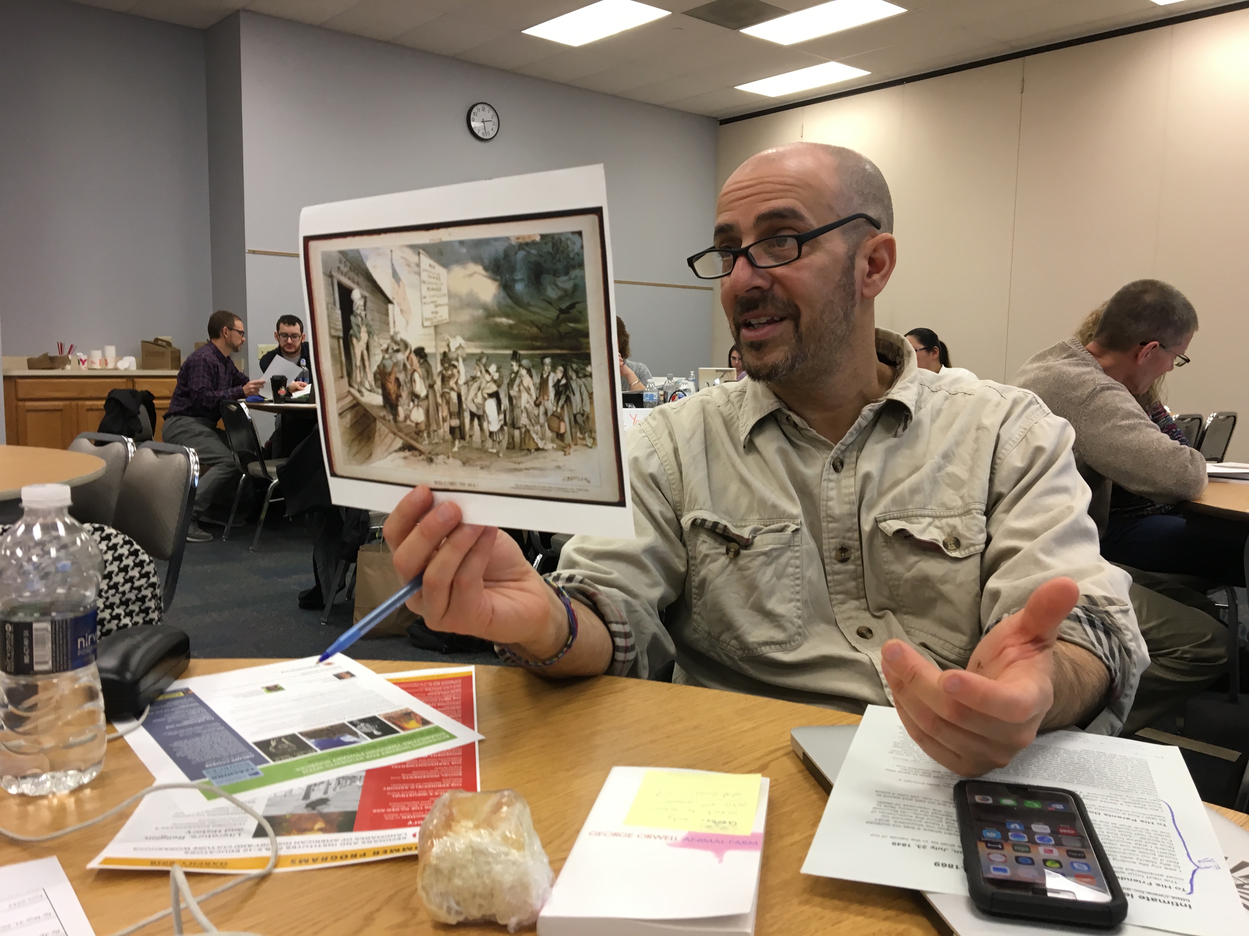 A teacher holds up a political cartoon for discussion