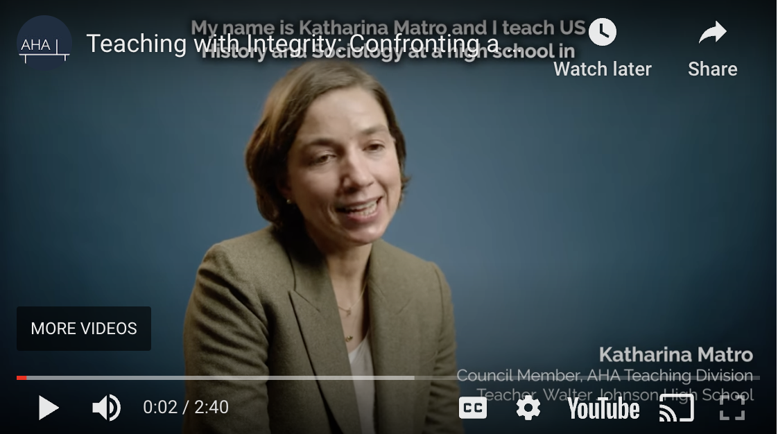 Screenshot of Ms. Matro's YouTube video interview; she sits in front of a plain backdrop, professional in a blazer, with chin-length brown hair, white skin, her face partly in shadow,