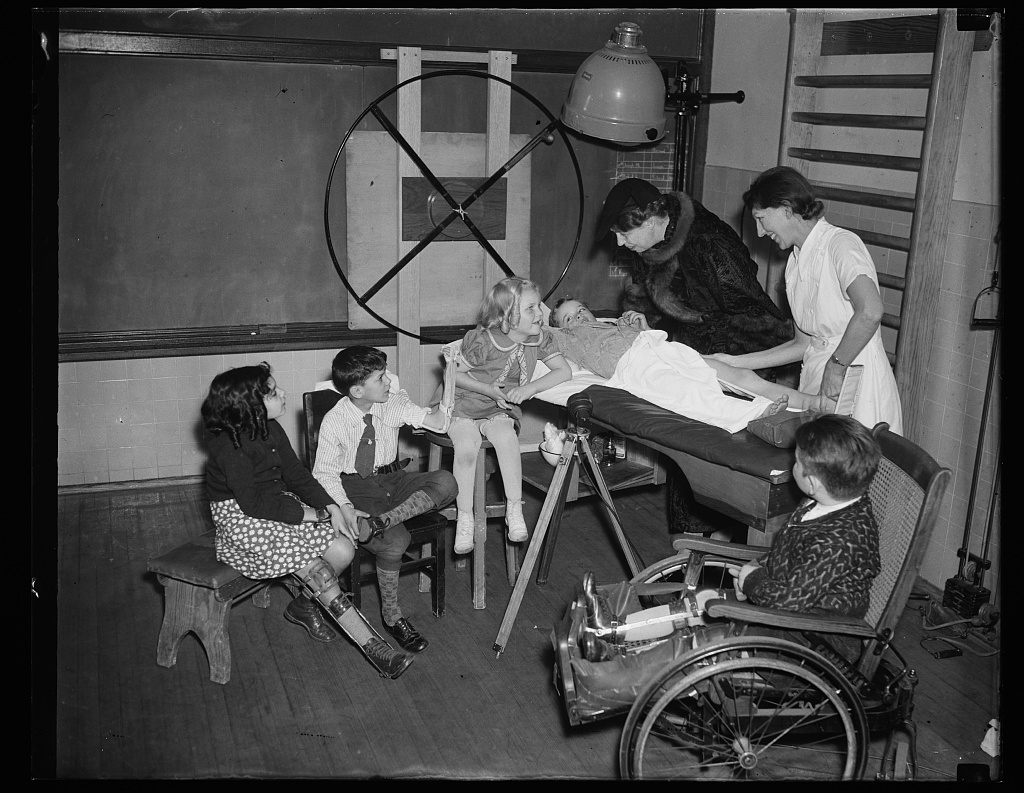 First Lady Eleanor Roosevelt visits students in a school for students with disabilities. Some students show visible signs of mobility-related disability. 