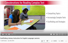 Two high school girls at a shared desk with papers in front of them. Captions show it is a screen shot of a video on teaching English Learners.